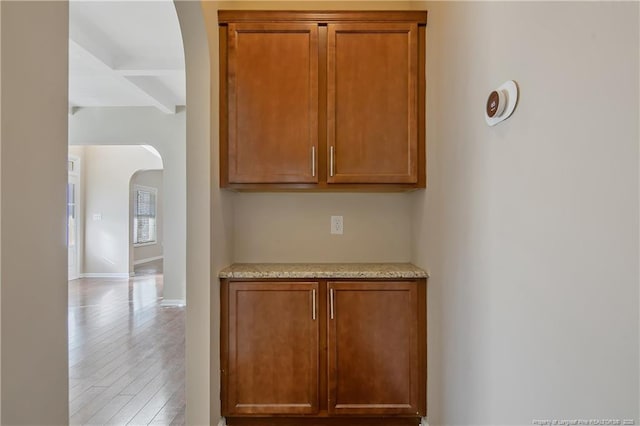 interior space featuring beam ceiling and light hardwood / wood-style flooring