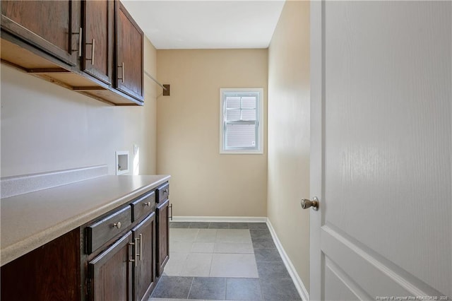 washroom featuring hookup for a washing machine, cabinets, and light tile patterned flooring