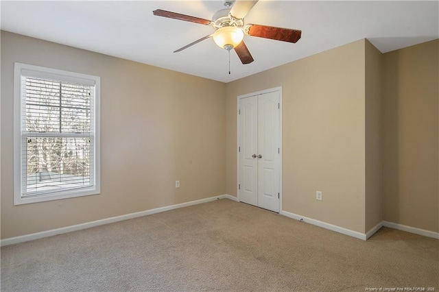 spare room featuring light carpet and ceiling fan