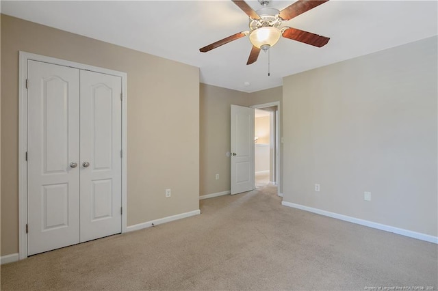 unfurnished bedroom featuring light colored carpet, a closet, and ceiling fan