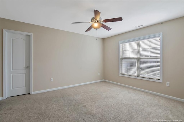 carpeted spare room featuring ceiling fan