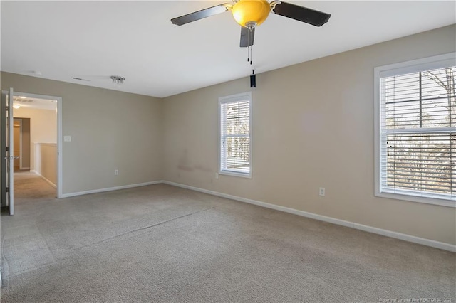 carpeted spare room featuring ceiling fan