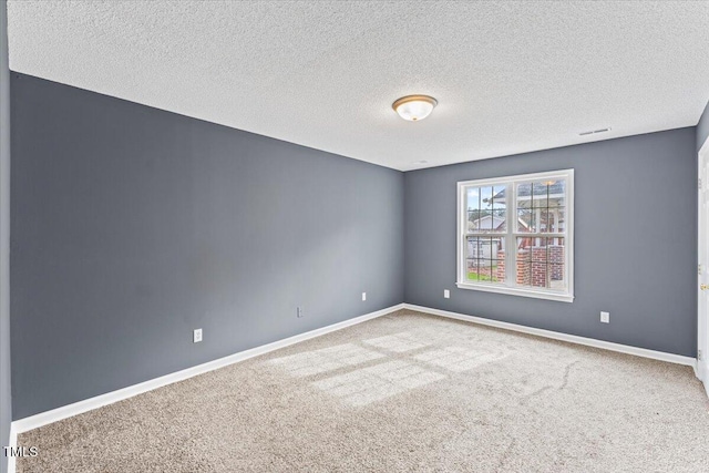 carpeted spare room featuring a textured ceiling