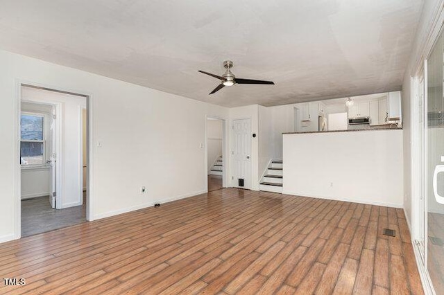 unfurnished living room featuring hardwood / wood-style floors and ceiling fan