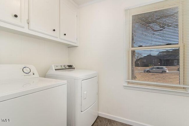 clothes washing area with washing machine and dryer and cabinets