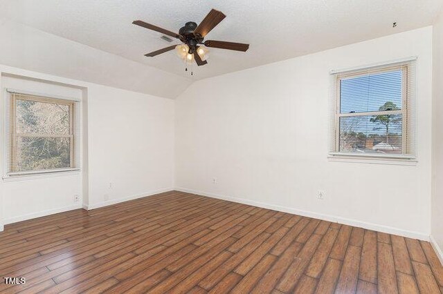 unfurnished room with dark hardwood / wood-style flooring, vaulted ceiling, and ceiling fan