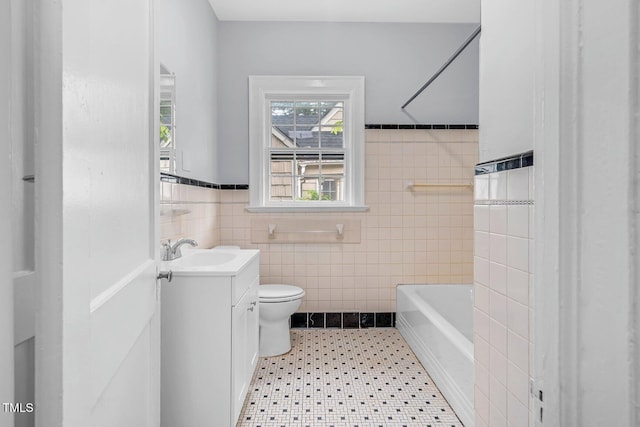945 Sycamore St, Rocky Mount, NC 27801 - full bath with vanity, toilet, tile walls, a tub to relax in, and wainscoting