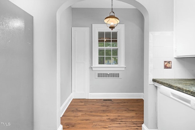 945 Sycamore St, Rocky Mount, NC 27801 - unfurnished dining area featuring arched walkways, wood finished floors, and baseboards