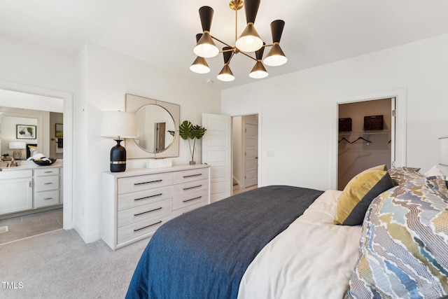 bedroom featuring connected bathroom, a spacious closet, light colored carpet, and a closet