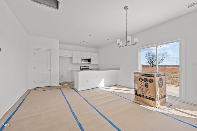 kitchen with white cabinetry, hanging light fixtures, a notable chandelier, and stainless steel appliances