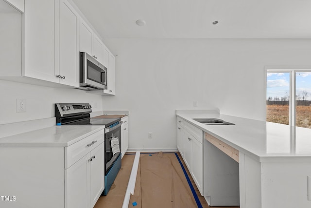 kitchen featuring white cabinetry, stainless steel appliances, and kitchen peninsula