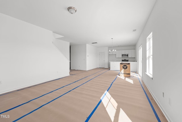 unfurnished living room with a chandelier