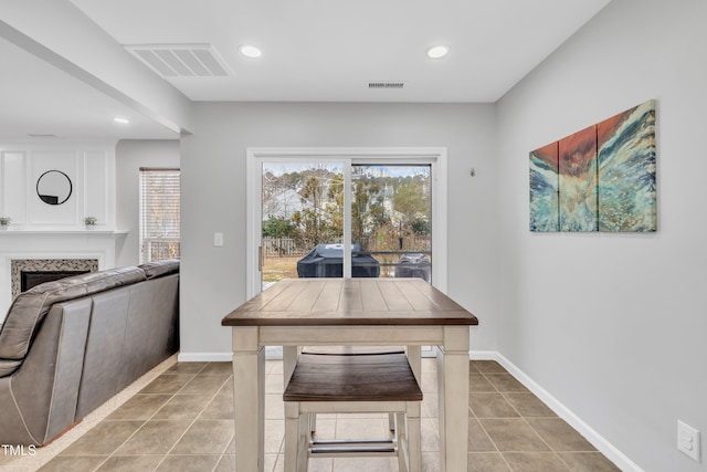 tiled dining room with a fireplace