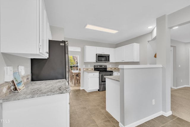 kitchen with white cabinetry, appliances with stainless steel finishes, light stone counters, and light carpet