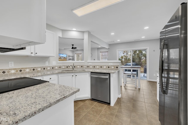 kitchen with sink, white cabinetry, appliances with stainless steel finishes, kitchen peninsula, and ceiling fan