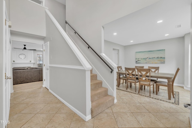 stairway featuring tile patterned flooring and ceiling fan