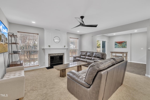 living room with ceiling fan, light colored carpet, a large fireplace, and a wealth of natural light