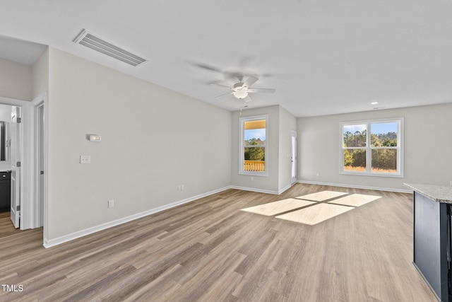 unfurnished living room featuring ceiling fan and light hardwood / wood-style flooring