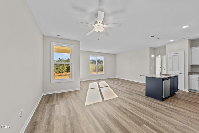 unfurnished living room featuring sink, light hardwood / wood-style floors, and ceiling fan