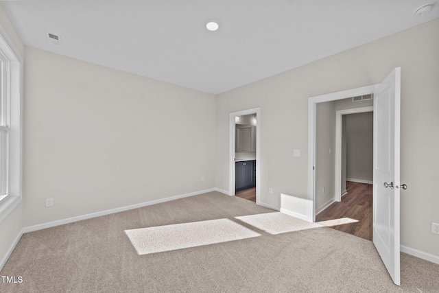 unfurnished bedroom featuring multiple windows and light carpet