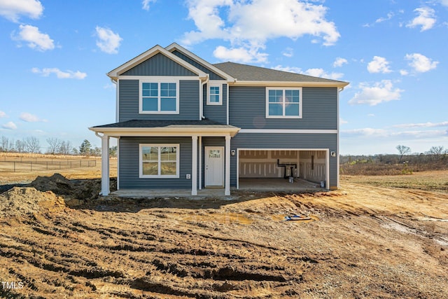 view of front of home featuring a garage and a rural view