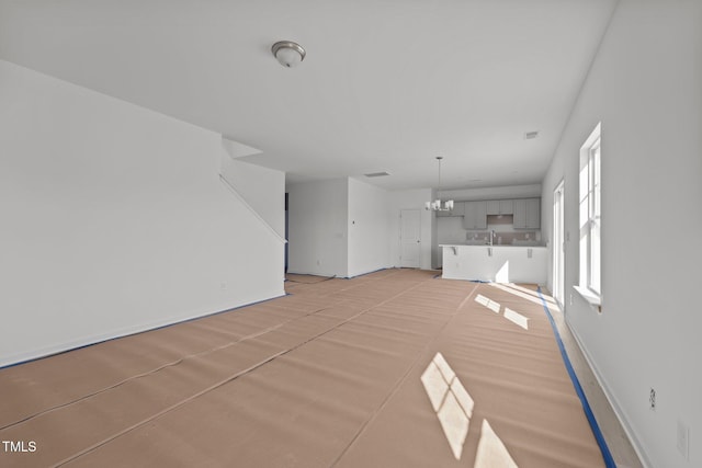 unfurnished living room with a chandelier