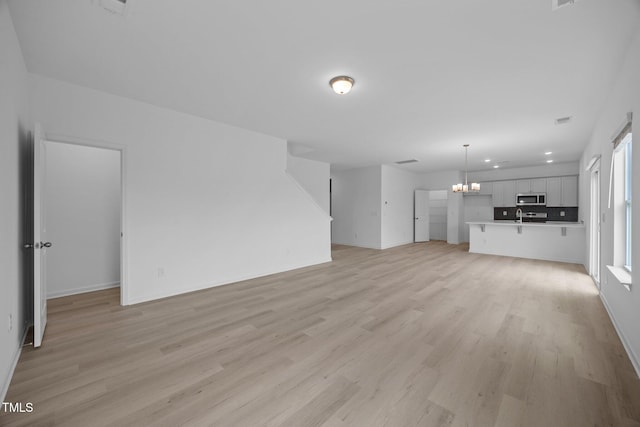 3615 62, Burlington, NC 27217 - unfurnished living room featuring recessed lighting, visible vents, baseboards, light wood-style flooring, and a notable chandelier