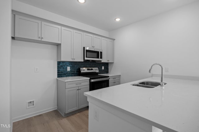 3615 62, Burlington, NC 27217 - kitchen with light wood-style floors, appliances with stainless steel finishes, gray cabinets, and a sink