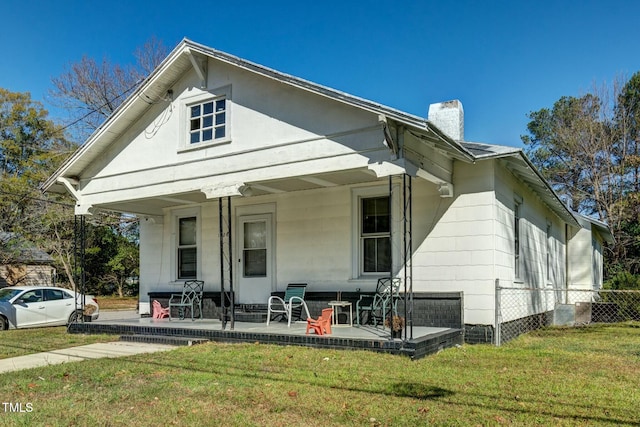 view of front of home featuring covered porch and a front lawn