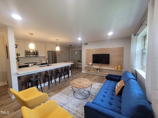 living room with sink and light wood-type flooring