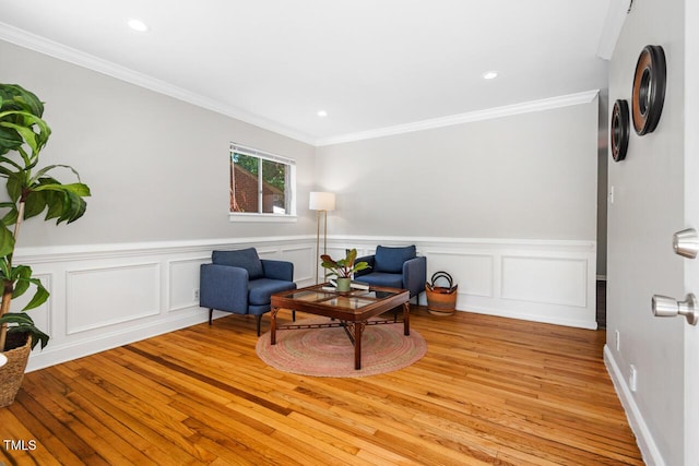 sitting room with ornamental molding and light hardwood / wood-style floors