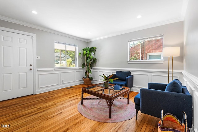 living room featuring ornamental molding and light hardwood / wood-style floors