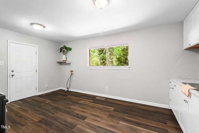 laundry room featuring hookup for a washing machine, dark wood-type flooring, and cabinets