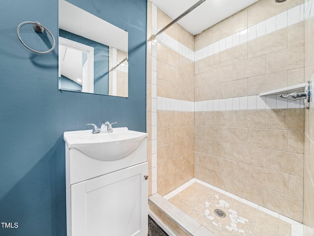 bathroom with vanity and tiled shower