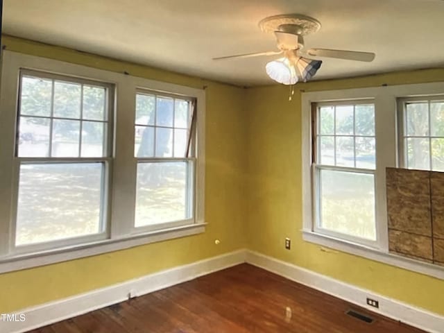 spare room featuring dark wood-type flooring and ceiling fan