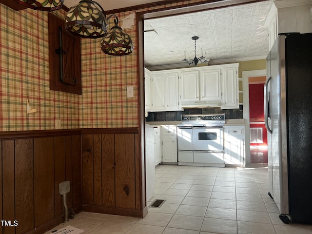 kitchen with double oven range, crown molding, stainless steel fridge, and white cabinets