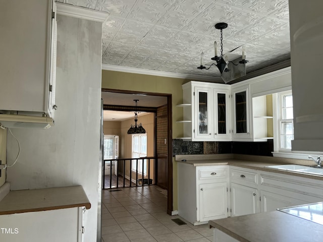 kitchen featuring pendant lighting, a notable chandelier, a healthy amount of sunlight, and white cabinets