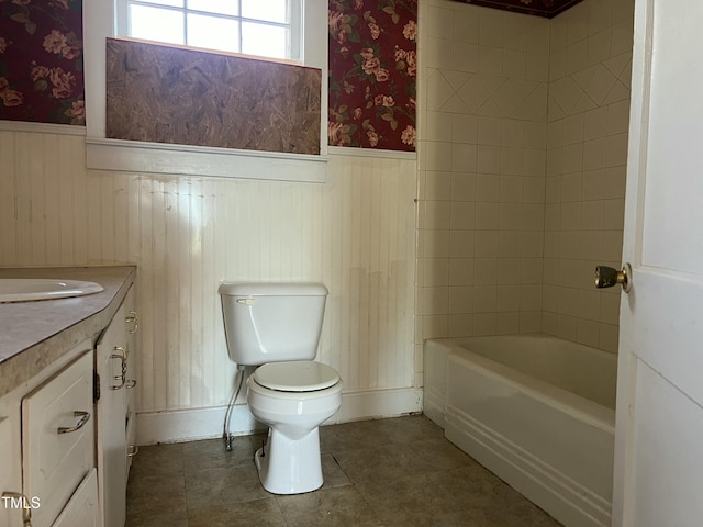 full bathroom featuring vanity, tiled shower / bath combo, and toilet