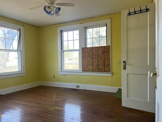 spare room featuring ceiling fan, dark hardwood / wood-style floors, and a wealth of natural light