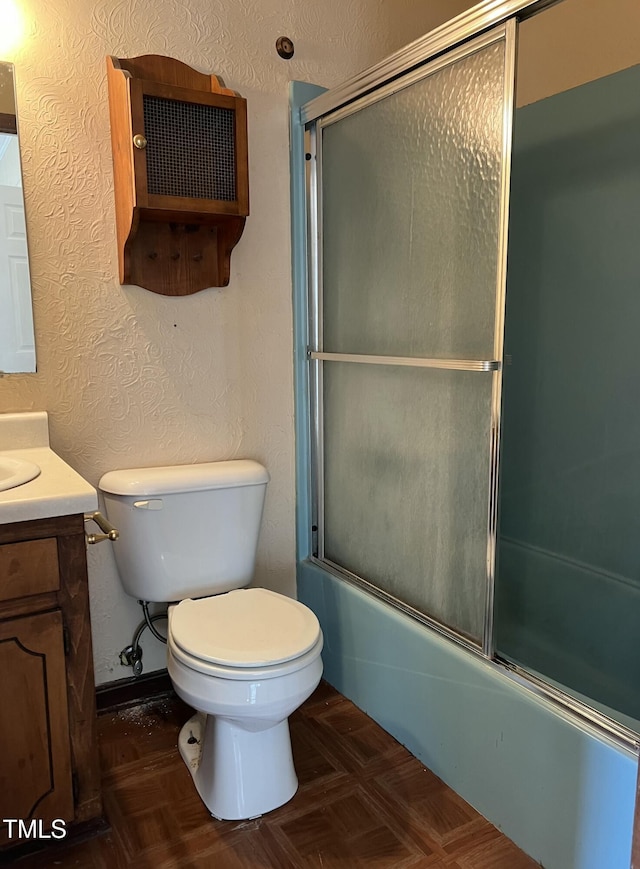 full bathroom featuring vanity, parquet flooring, shower / bath combination with glass door, and toilet