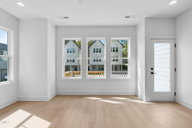 unfurnished room featuring plenty of natural light and light hardwood / wood-style floors