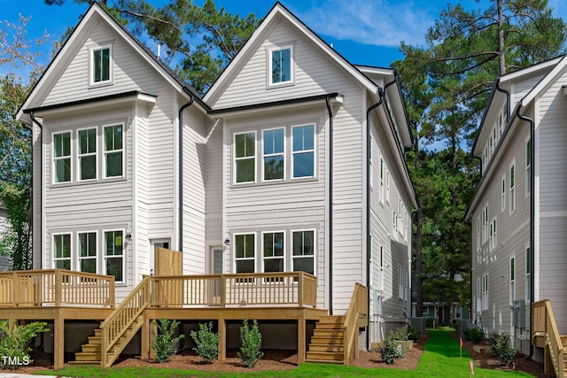 rear view of house featuring a yard and a deck