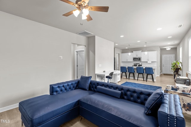 living room featuring ceiling fan and light wood-type flooring