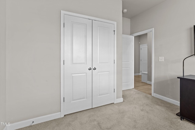 unfurnished bedroom featuring light colored carpet and a closet