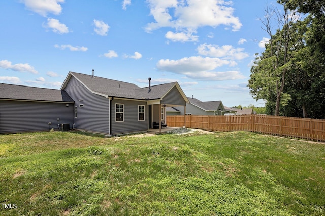 rear view of house with a lawn, central air condition unit, and a patio area