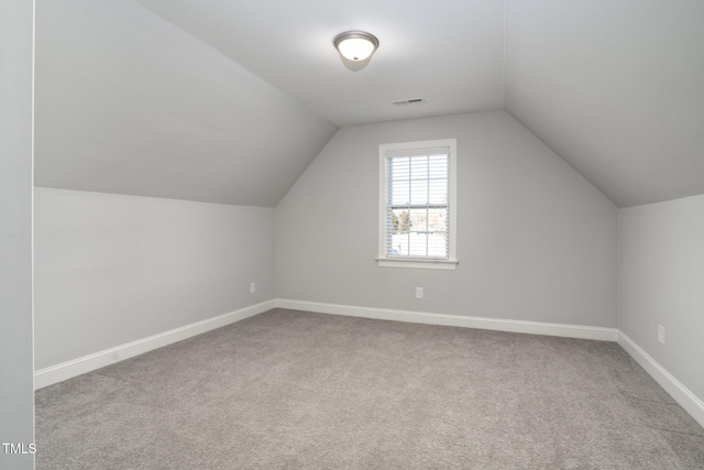 bonus room featuring vaulted ceiling and light carpet