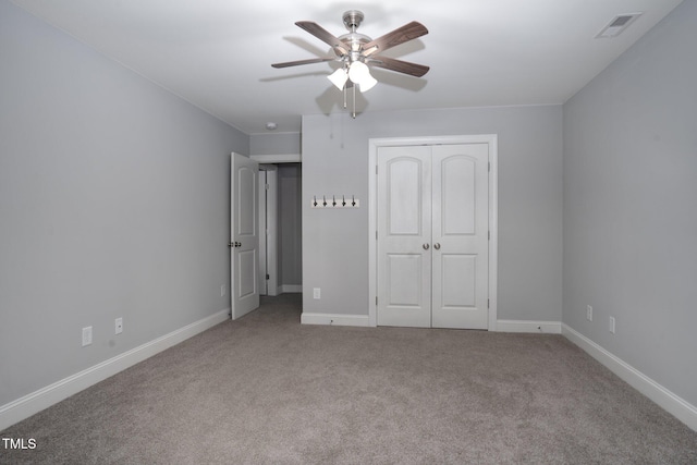 unfurnished bedroom with light colored carpet, a closet, and ceiling fan