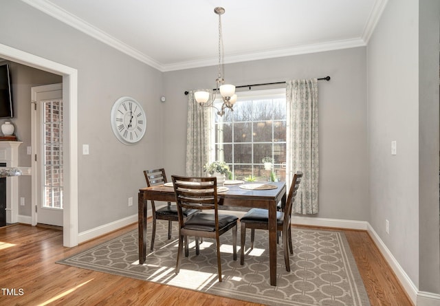 dining room with hardwood / wood-style flooring, ornamental molding, and a notable chandelier