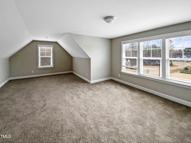 bonus room with vaulted ceiling and carpet