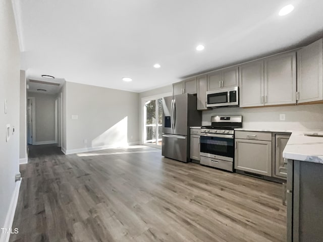 kitchen featuring hardwood / wood-style flooring, gray cabinets, and stainless steel appliances